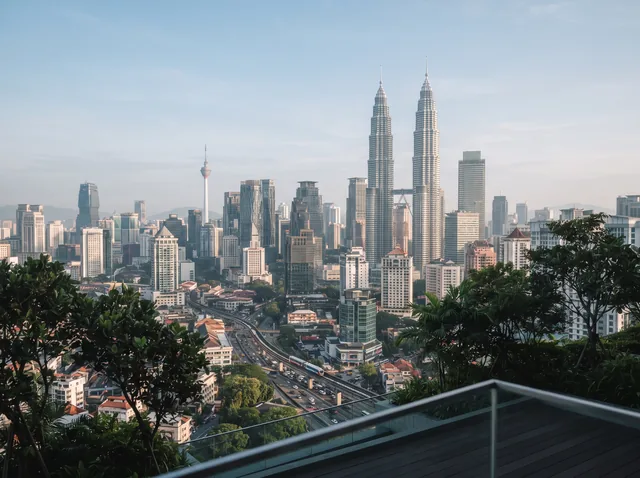 An editorial view of the Kuala Lumpur skyline and Petronas Twin Towers.