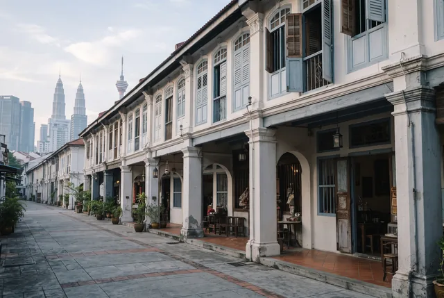 An illustrative Malaysian street with heritage shophouses and tropical trees.